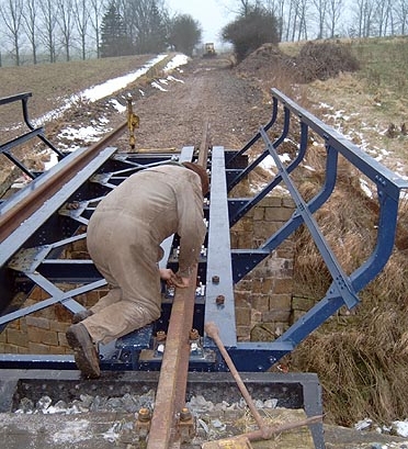 Zum Schluss wurden die Schienen mit den oben erwähnten Passschrauben am Brückenträger befestigt.  Im Hintergrund sieht man schon die planierte Trasse.  